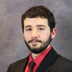 Image of man with red shirt, black blazer and black tie